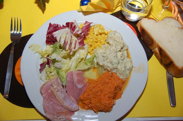 Salatteller mit Hamme und Züpfe. Darunter ein gelbes Tischset mit zwei schwarzen Singles (Schallplatten)