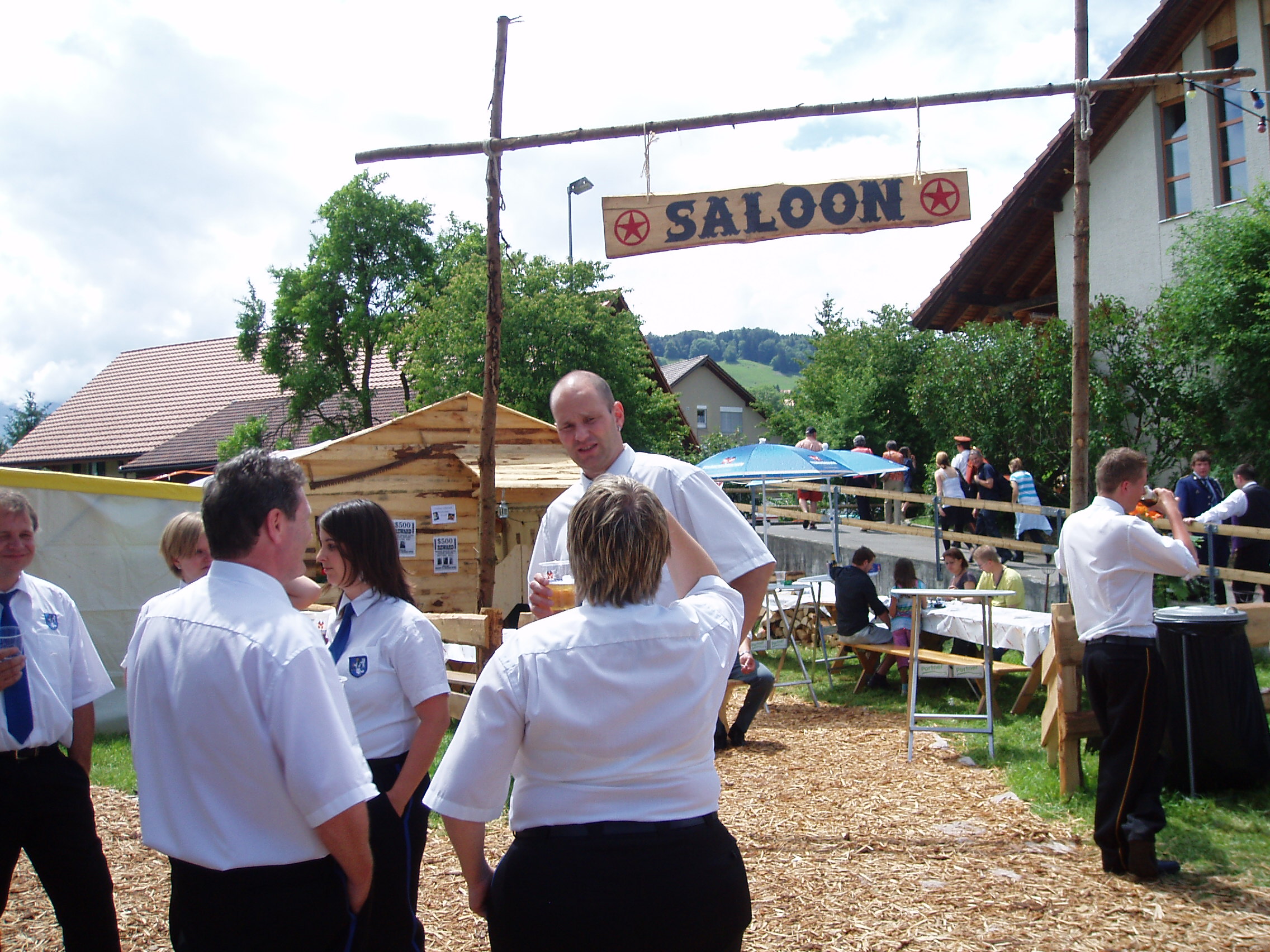Musizierende mit weissen Hemden vor dem Saloon.