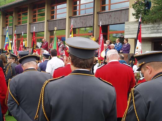 Musikanten und Fahnen vor der Turnhalle.
