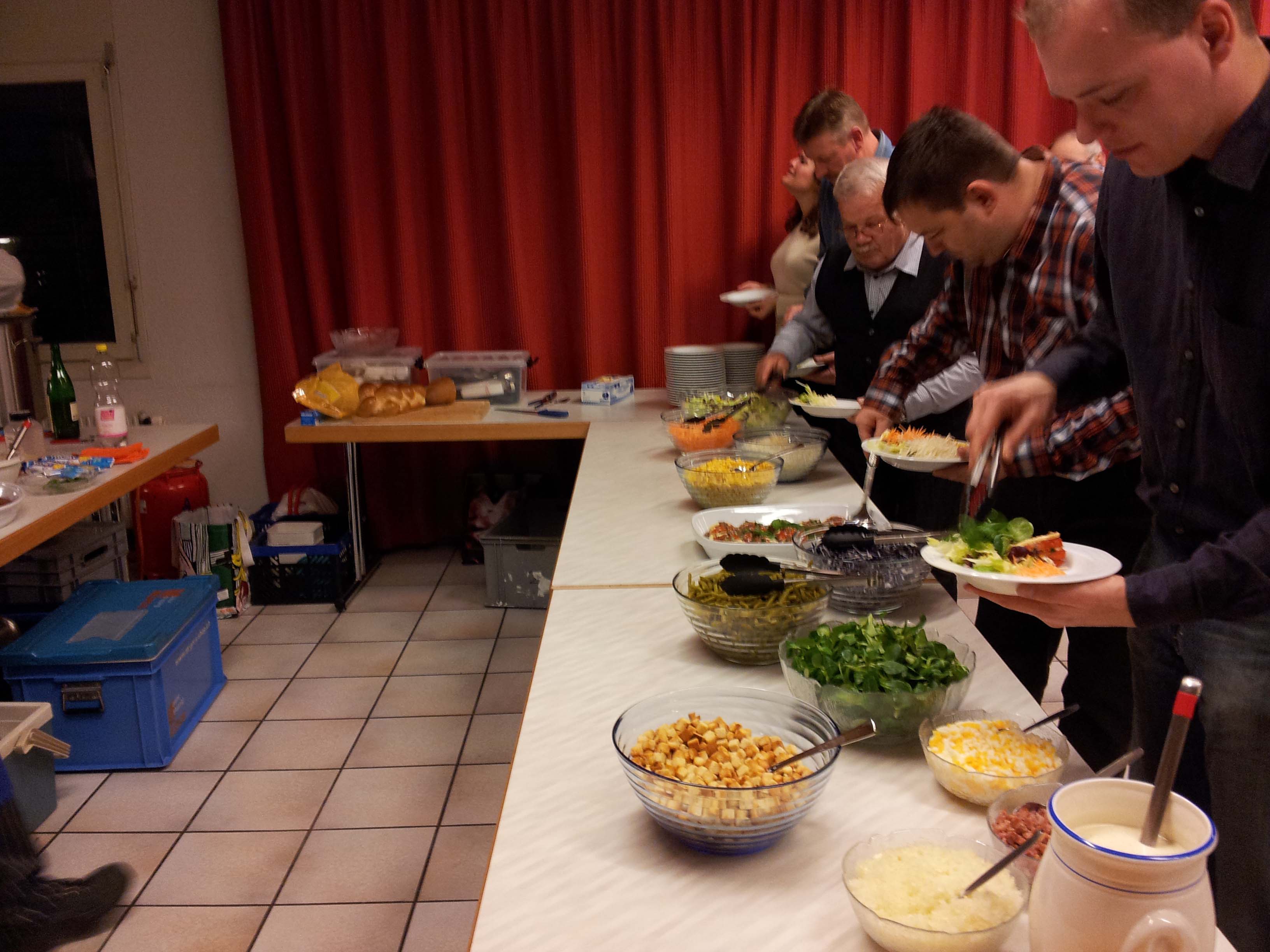 Personen am Schöpfen von Köstlichkeiten.