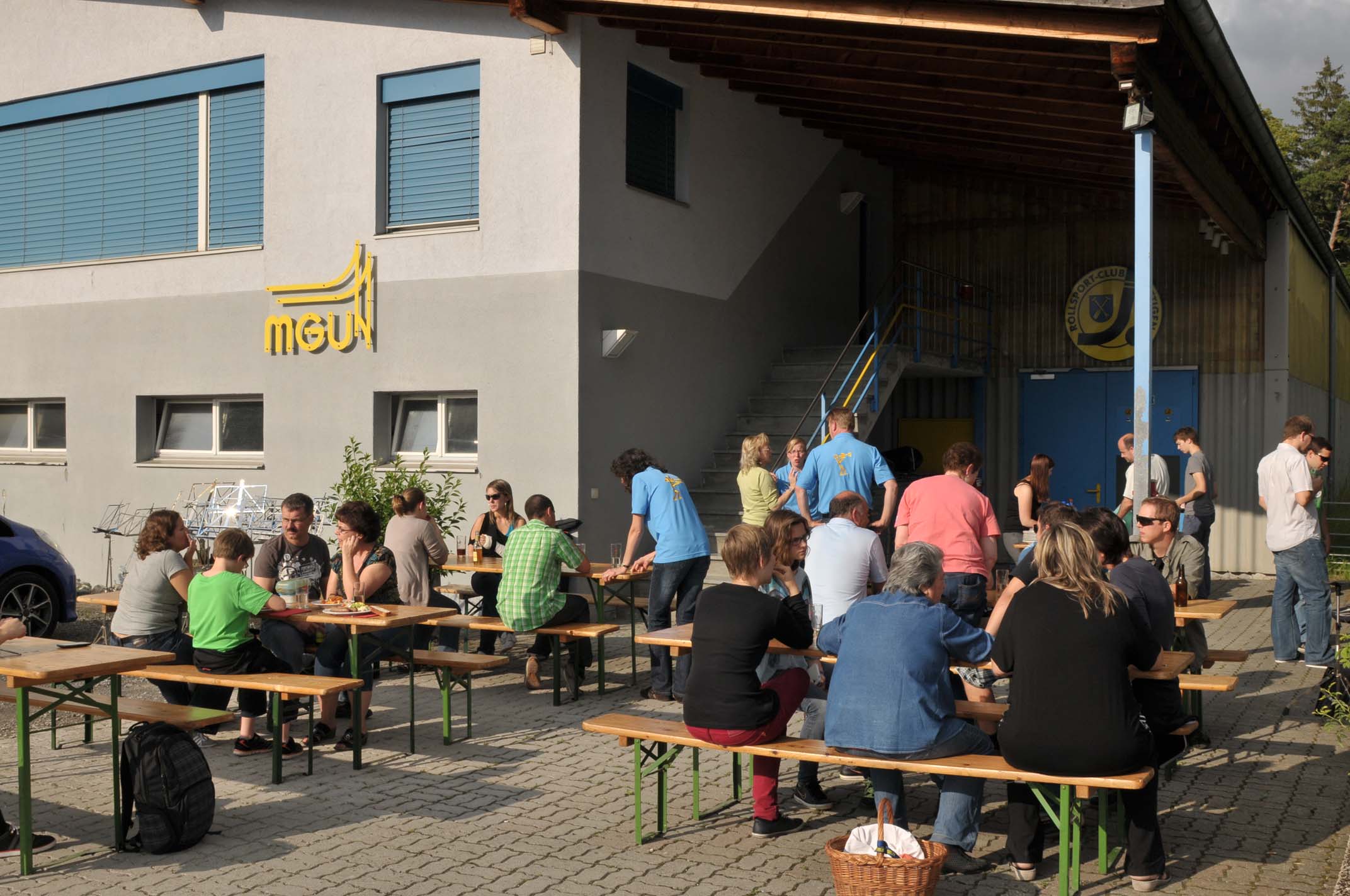 Personen auf Festbänken vor dem Probelokal Grüeneblätz.