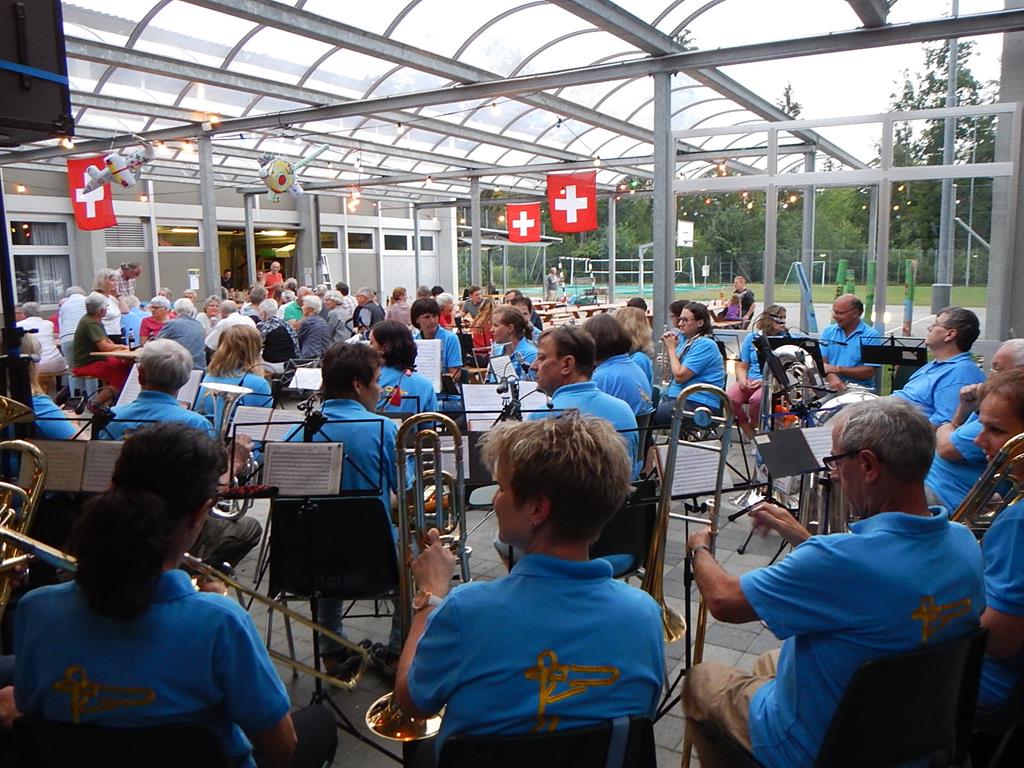Die MGU mit blauen T-Shirts unter dem Baldachin beim Schulhaus.