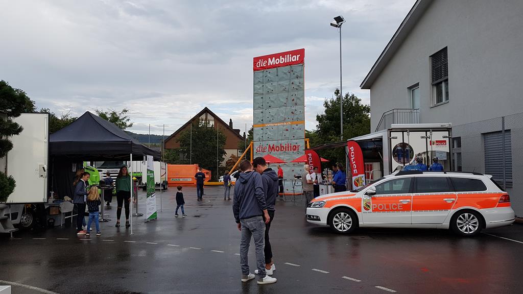 Stände auf dem Pausenplatz. Vorne rechts steht ein VW Passat Kombi; ein Patrouillenfahrzeug der Kantonspolizei Bern.