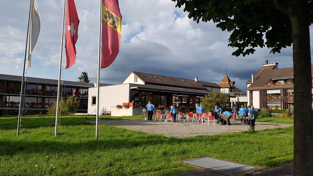 Im Vordergrund die drei Fahnen vom Altersheim. Etwas weiter weg sitzt die MGU mit ihren blauen T-Shirts.